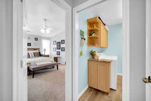 Bedroom featuring ceiling fan, light hardwood / wood-style flooring, and washer / clothes dryer