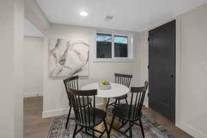 Basement Dining space with hardwood / wood-style flooring