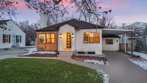 View of front of property with a lawn and a carport