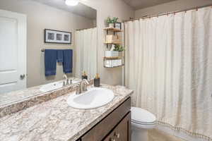 Bathroom with toilet, vanity, and tile patterned flooring