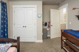 Bedroom featuring light colored carpet and a closet