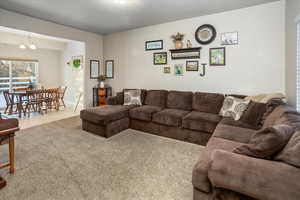 Living room featuring an inviting chandelier and carpet flooring