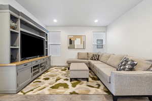 Living area with baseboards, light wood-type flooring, and recessed lighting