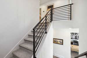Staircase with visible vents and baseboards