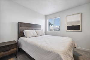 Bedroom featuring a textured ceiling, carpet, and baseboards
