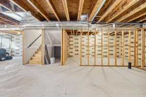 Unfinished below grade area featuring stairway