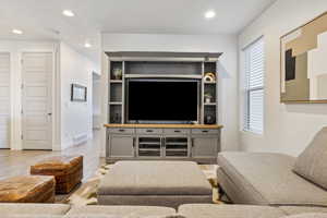 Living room with baseboards, wood finished floors, visible vents, and recessed lighting