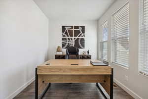 Office space featuring baseboards and dark wood-style flooring