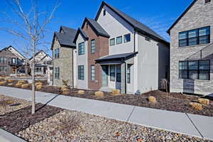 View of front of house featuring brick siding, a shingled roof, and a residential view