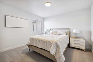 Bedroom with a textured ceiling, carpet, and baseboards