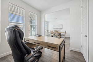 Office space with baseboards and dark wood-style flooring