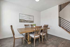 Dining room featuring baseboards, stairway, and wood finished floors