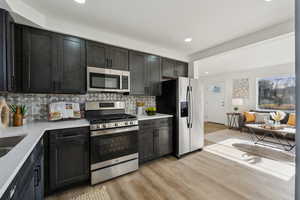 Kitchen with stainless steel appliances, gas range, and tasteful backsplash