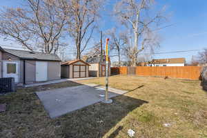 View of yard with a patio area, central AC, and a sheds