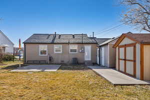 Back of house with a yard, a patio area, and a storage shed