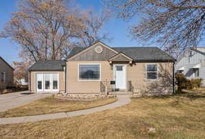 View of front of house with a front yard and french doors