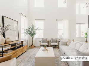 Living room featuring light hardwood / wood-style floors and a towering ceiling