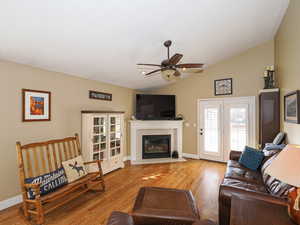 Living room with a fireplace double doors lead to covered deck.