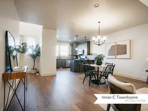 Dining space featuring a notable chandelier, sink, and wood-type flooring