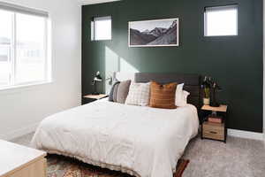 Carpeted bedroom featuring multiple windows, and vaulted ceiling