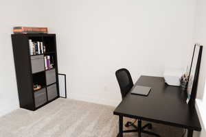 Office space/bedroom featuring light colored carpet