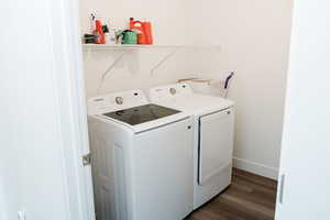 Laundry room featuring light LVP floors and washer and clothes dryer