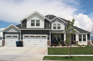 Craftsman house featuring a garage and a front yard