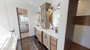 Bathroom featuring vanity, tile patterned floors, and a chandelier