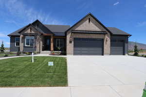 View of front of house with a garage and a front lawn