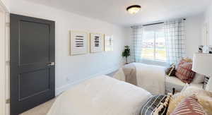 Bedroom with light colored carpet and a textured ceiling