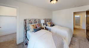 Bedroom featuring a closet, light carpet, and a walk in closet