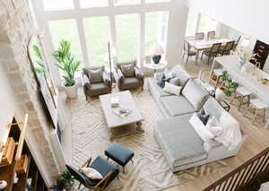 Living room with light hardwood / wood-style flooring and a high ceiling