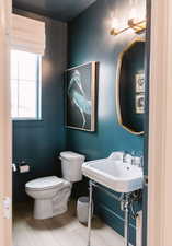 Bathroom featuring wood-type flooring, sink, and toilet