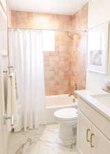 Full bathroom featuring shower / bath combination with curtain, vanity, and toilet