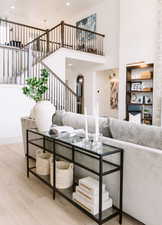 Living room featuring a towering ceiling and wood-type flooring