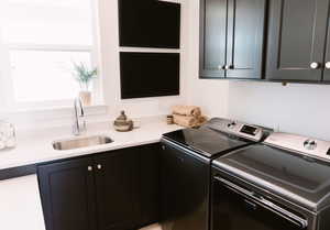 Laundry room with cabinets, separate washer and dryer, and sink
