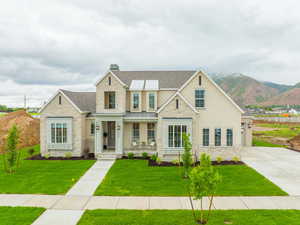 View of front of property with a mountain view, a porch, and a front lawn