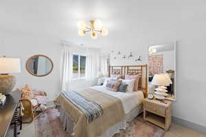 Bedroom with light carpet and a chandelier