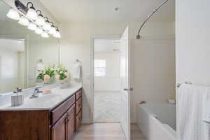 Bathroom featuring hardwood / wood-style flooring, vanity, and bathing tub / shower combination