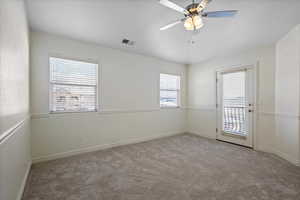 Empty room with ceiling fan, light colored carpet, and a wealth of natural light