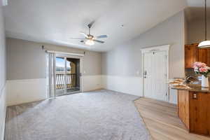 Unfurnished room with ceiling fan, sink, light colored carpet, and vaulted ceiling