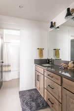 Bathroom featuring tile patterned floors, vanity, and walk in shower