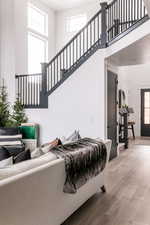 Living room featuring plenty of natural light, light wood-type flooring, and a towering ceiling