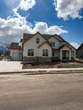 View of front of property featuring driveway, roof with shingles, and a garage