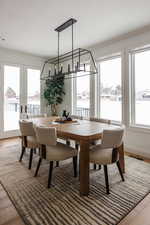 Dining room with crown molding, hardwood / wood-style floors, a water view, and french doors