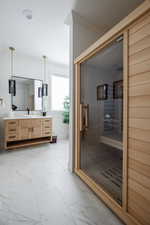 Bathroom featuring walk in shower, vanity, and crown molding