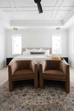 Bedroom with coffered ceiling, multiple windows, carpet floors, and ceiling fan