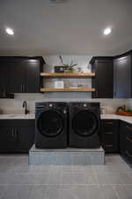 Laundry area with sink, cabinets, and independent washer and dryer