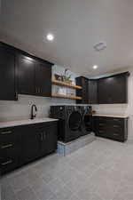 Laundry area with sink, cabinets, and washing machine and dryer