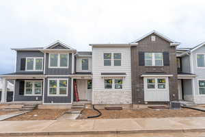 Multi unit property with central air condition unit, board and batten siding, and stone siding